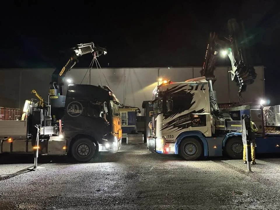 Två STC-lastbilar natt vid industrihall